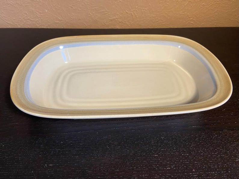 May include: A set of three ceramic mugs with a speckled, matte finish. The mugs are in shades of cream, light gray, and dark gray. Each mug has a simple, minimalist design, perfect for coffee or tea.