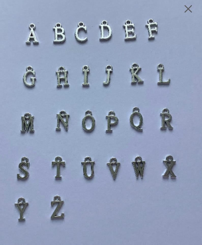 May include: Silver alphabet letter charms, A through Z, with a loop at the top for attaching to jewelry or other crafts.