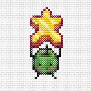May include: A cross-stitch pattern featuring a green, square-shaped character with a small stem, black eyes, and pink cheeks, holding a large, five-pointed yellow star with a dark red outline above its head against a white grid background.