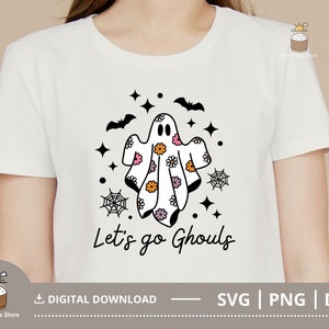 Pu&ograve; includere: Maglietta bianca con un'illustrazione in bianco e nero di un fantasma con motivi floreali. Il testo "Let's go Ghouls" &egrave; stampato sotto il fantasma.