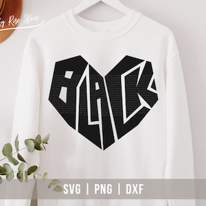 May include: White sweatshirt with a black heart-shaped design that says "BLACK" inside. The design is made up of the word "BLACK" repeated many times. The sweatshirt is on a white background.