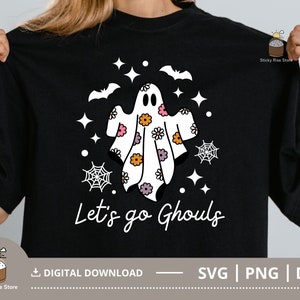 Pu&ograve; includere: Maglietta nera con un design di fantasma bianco con fiori rosa, arancioni e viola. Il fantasma &egrave; circondato da stelle e ragnatele. Il testo "Let's go Ghouls" &egrave; stampato sotto il fantasma.