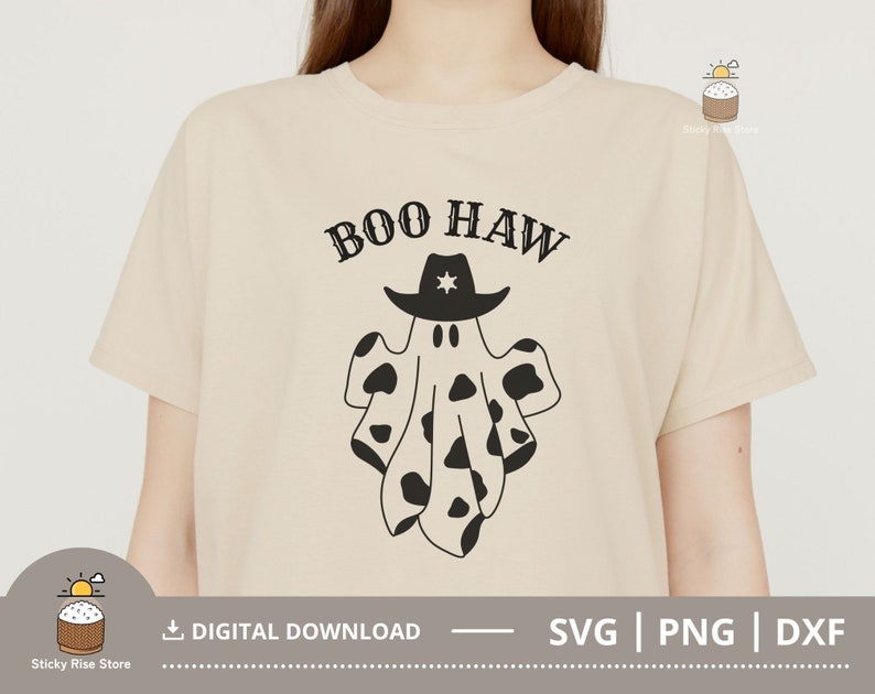 Puede incluir: Una camiseta beige con un gr&aacute;fico en blanco y negro de un fantasma con un sombrero de vaquero. El texto "BOO HAW" est&aacute; impreso sobre el fantasma.