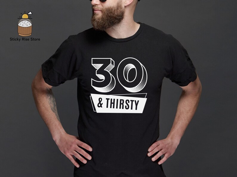May include: Black t-shirt with the text "30 & Thirsty" in white. The number "30" is in a 3D style, and the text is on a white banner. The shirt is a crew neck style.