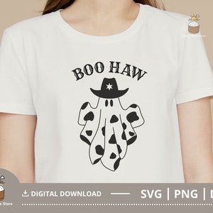 Puede incluir: Camiseta blanca con un fantasma blanco y negro que lleva un sombrero de vaquero. El texto "BOO HAW" est&aacute; por encima del fantasma.