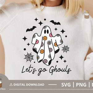Pu&ograve; includere: Maglia bianca con un fantasma grafico e il testo "Let's go Ghouls". Il fantasma &egrave; decorato con fiori rosa, arancioni e gialli.