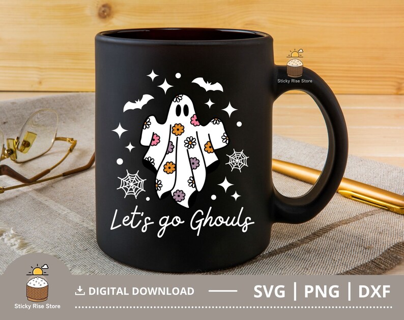 Pu&ograve; includere: Tazza da caff&egrave; nera con un fantasma bianco che indossa un motivo floreale e il testo "Let's go Ghouls".
