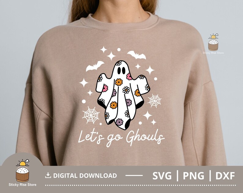 Pu&ograve; includere: Una felpa color beige con un disegno di un fantasma e il testo "Let's go Ghouls". Il fantasma &egrave; bianco con fiori rosa, viola e gialli. Il design &egrave; perfetto per Halloween.