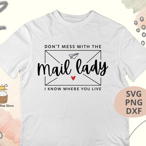 May include: White t-shirt with a black and white graphic design of an envelope with a paper airplane and the text "Don't mess with the mail lady I know where you live".
