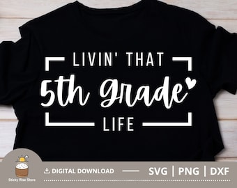 May include: Black t-shirt with white text that reads "Livin' That 5th Grade Life" with a small heart after "grade".