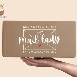 May include: A brown cardboard box with the text "Don't mess with the mail lady I know where you live" printed on it. The text is in a white font with a red heart.