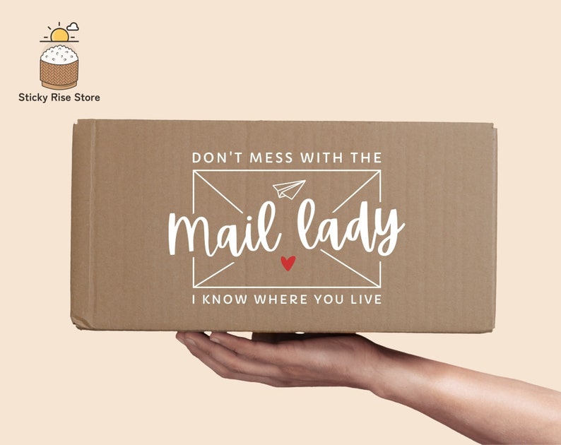 May include: A brown cardboard box with the text "Don't mess with the mail lady I know where you live" printed on it. The text is in a white font with a red heart.