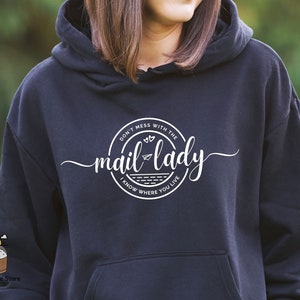 May include: Black hoodie with a white graphic that says "Don't mess with the mail lady I know where you live" in a circle with a paper airplane and hearts.