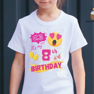 K&ouml;nnte beinhalten: Wei&szlig;es T-Shirt mit einer pinkfarbenen und gelben Grafik, auf der "OMG it's my 8th BIRTHDAY" steht. Die Grafik enth&auml;lt ein gelbes Emoji mit pinkfarbenen Herzen als Augen und einer pinkfarbenen Zahl 8.