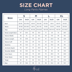 Op de afbeelding: Maattabel voor lange pyjamabroeken, met afmetingen in centimeters en inches. Inclusief borstomvang, taille, heupen, mouwlengte en andere afmetingen voor de maten S, M, L en XL. De tabel heeft een marineblauwe achtergrond.