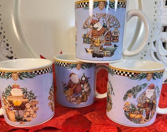 May include: Four ceramic mugs with a light blue background and Santa Claus illustrations. Each mug has a white handle and a black and white checkered pattern at the rim. The mugs are decorated with pine cones and winter scenes.