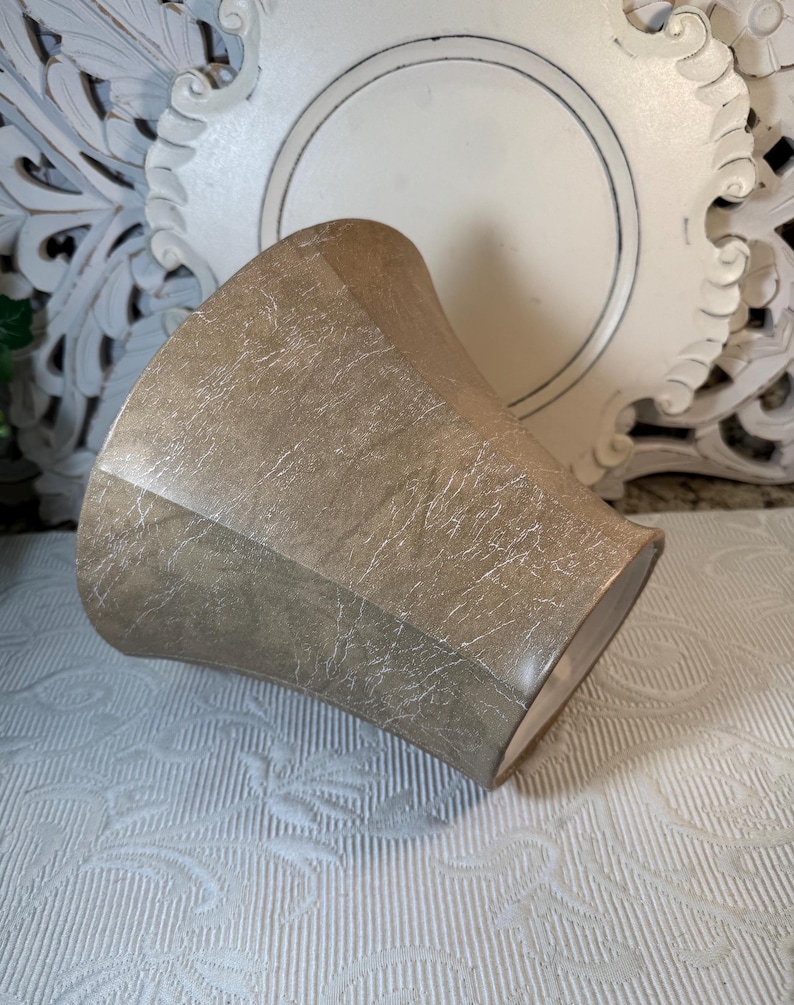 May include: A light brown, textured, ceramic planter with a wide, flared opening. The planter has a slightly distressed look, giving it a vintage feel.