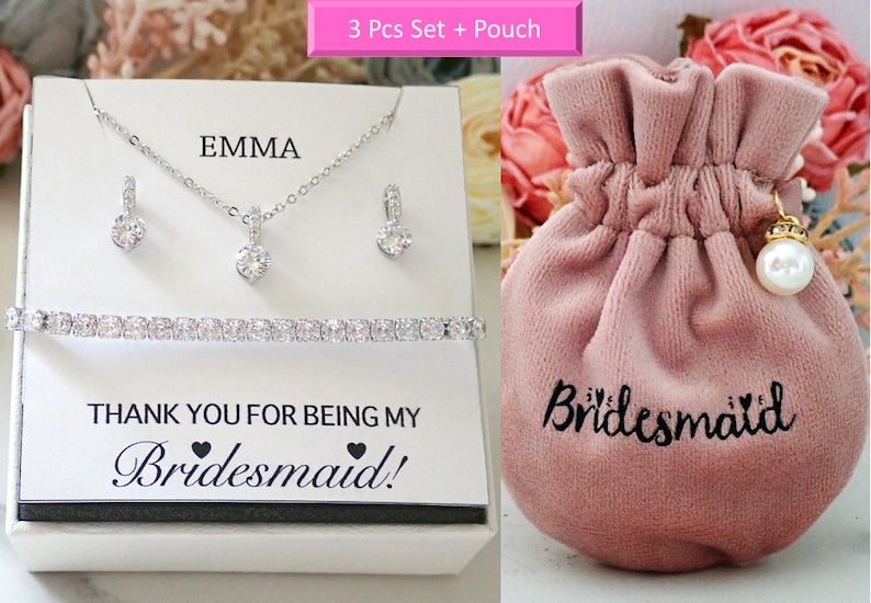 May include: A jewelry set featuring a silver-toned necklace, two earrings, and a tennis bracelet with clear stones. The display card reads EMMA and THANK YOU FOR BEING MY Bridesmaid!. A pink velvet drawstring pouch is labeled with Bridesmaid.