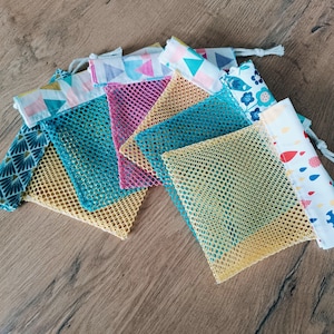 May include: A set of six colourful mesh laundry bags with different patterned fabric tops. The bags are made of a fine mesh material and are ideal for washing delicate items.