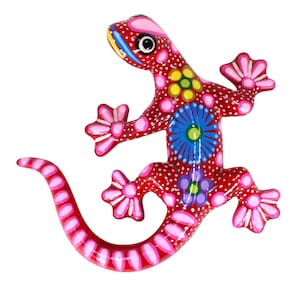 Könnte beinhalten: Handbemalte Holz-Echsenfigur. Der rote Körper ist mit weißen Punkten und bunten Blumenmustern in Blau, Gelb und Lila verziert. Die Füße und der Schwanz der Eidechse sind mit rosa und weißen Akzenten versehen.