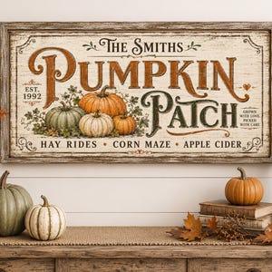 以下が含まれることがあります： 使い古された白い仕上げの長方形の木製看板。The Smiths Pumpkin Patch, Est. 1992という文字と、Hay Rides, Corn Maze, Apple Ciderという言葉が書かれています。グラフィックには、オレンジと緑のカボチャ、秋の紅葉が含まれています。