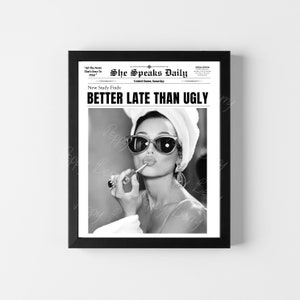 May include: Black and white newspaper style print with a woman wearing sunglasses and a towel on her head applying lipstick. The headline reads "Better Late Than Ugly".