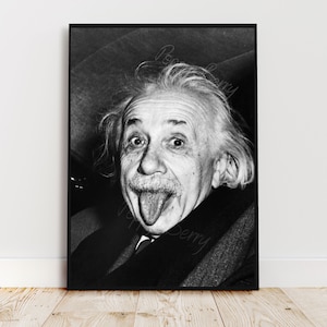 May include: Black and white portrait of Albert Einstein sticking his tongue out. The photo is taken from a slightly low angle, showing Einstein's face and hair.