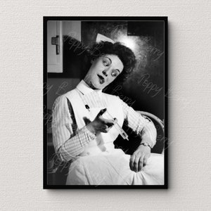 May include: Black and white photo of a woman dressed as a nurse holding a syringe. She is looking to the left of the frame and has a serious expression on her face.