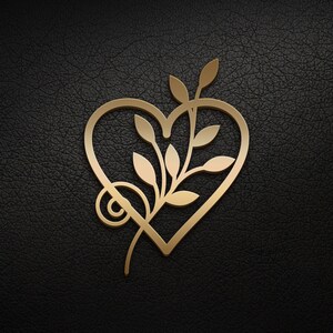 May include: A gold-colored heart-shaped design with a stylized branch and leaves inside. The design is on a black textured background.