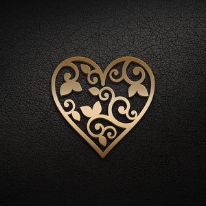 May include: A gold-colored heart-shaped design with intricate floral patterns cut out. The design is on a black background.