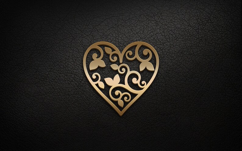 May include: A gold-colored heart-shaped design with intricate floral patterns cut out. The design is on a black background.