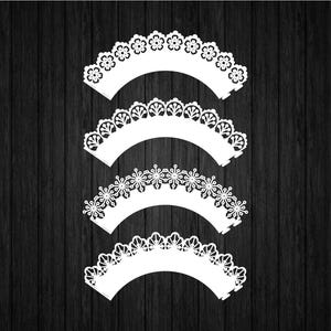 Puede incluir: Cuatro envoltorios blancos decorativos para cupcakes con intrincados diseños de encaje, dispuestos sobre un fondo oscuro de vetas de madera. Los envoltorios presentan patrones florales y geométricos, ideales para hornear y manualidades.