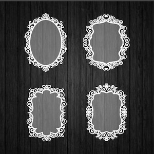 May include: Four white ornate decorative frames in different shapes against a dark wood grain background. The frames include an oval, a rounded top, and two rectangular shapes, all with intricate scrollwork.