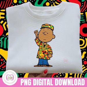 May include: White crewneck sweatshirt featuring a cartoon character in a colorful African-inspired outfit, raising a fist. The design includes the text "PNG DIGITAL DOWNLOAD" at the bottom.