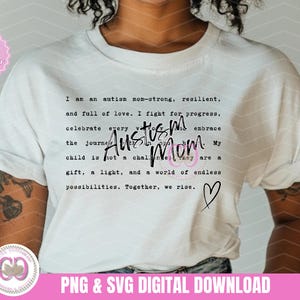 Op de afbeelding: Wit T-shirt met zwarte tekst die luidt: "Ik ben een autisme-mama, sterk, veerkrachtig en vol liefde. Ik vecht voor vooruitgang, vier elke reis, omarm de reis. Autisme-mama. Mijn kind is geen uitdaging, het is een geschenk, een licht en een wereld vol eindeloze mogelijkheden. Samen stijgen we op." Een zwart hart bevindt zich onder de tekst.