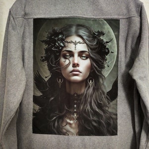 May include: A gray fleece jacket with a black and white image of a woman with long dark hair and a crown of black flowers. The image is on the back of the jacket.