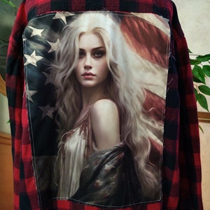 May include: Red and black plaid flannel shirt with a patch on the back featuring a woman with long blonde hair and an American flag.