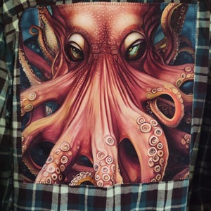 May include: A button-down flannel shirt with a large, detailed illustration of an octopus on the back. The octopus is rendered in shades of red, pink, and orange, with green eyes. The shirt itself is a plaid pattern in shades of green, black, and blue.