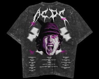 May include: A black and grey t-shirt with a faded, distressed look. The front features a large, graphic image of a man with a microphone, screaming. The text "AC/DC" is printed in a large, bold font above the image. The back of the shirt features a list of the band's albums and release dates printed in a smaller font.