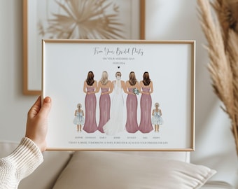May include: A framed print featuring a bridal party illustration. The artwork depicts a bride in a white gown with bridesmaids in pink dresses. The text reads "From Your Bridal Party" and includes names and a date. The frame is a light wood color.