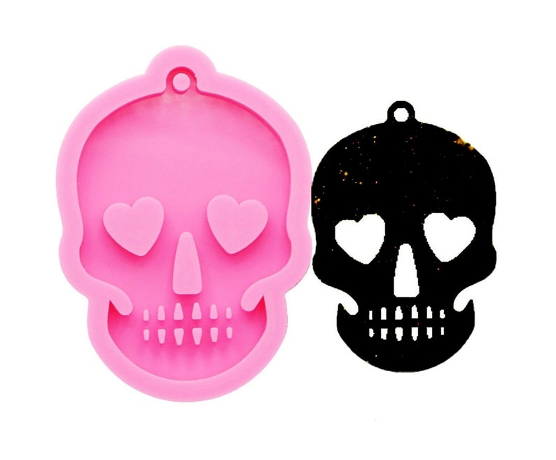 May include: Pink silicone mold of a skull with heart-shaped eyes. The mold is used to create resin crafts.