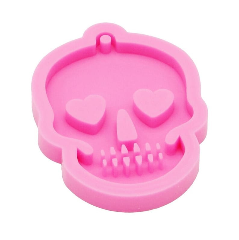May include: Pink silicone mold shaped like a skull with heart-shaped eyes. The mold is designed for making resin crafts.