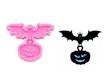 Puede incluir: Molde de silicona rosa de un murciélago posado sobre una calabaza. El molde está diseñado para hacer manualidades de resina.