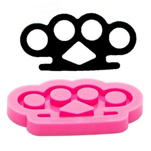 May include: Pink silicone mold shaped like a brass knuckle, a weapon with four knuckles.