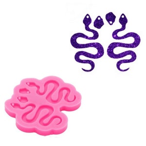 May include: Pink silicone mold with three snake shapes. The mold is designed to create resin earrings or other jewelry.