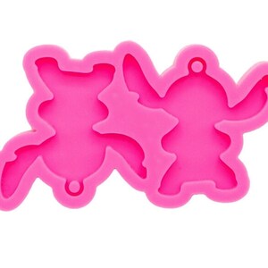 May include: Pink silicone mold for making resin charms or keychains. The mold features two Stitch characters from the Disney movie Lilo & Stitch.