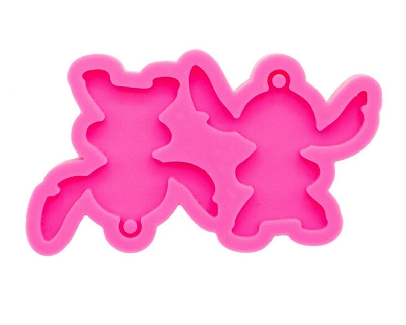 May include: Pink silicone mold for making resin charms or keychains. The mold features two Stitch characters from the Disney movie Lilo & Stitch.