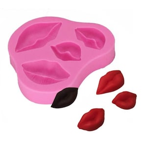 Pode incluir: Forma de silicone rosa com quatro formas de lábios. Há três lábios vermelhos sobre um fundo branco.