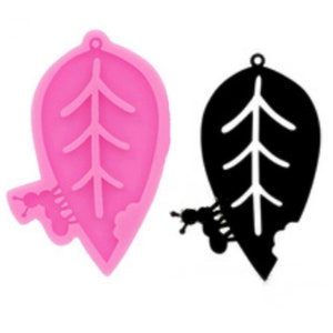 May include: Pink silicone mold shaped like a leaf with a small tree design inside. A small ant design is on the bottom left side of the mold.
