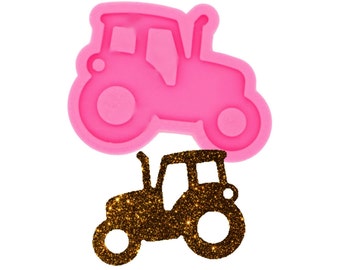 Puede incluir: Molde de silicona rosa de un tractor con una silueta de tractor de purpurina dorada.